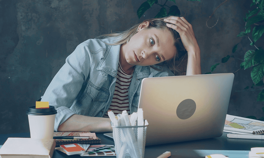 Stressed marketer staring at her laptop, needing SEO, AEO, and GEO strategy to get her business found online